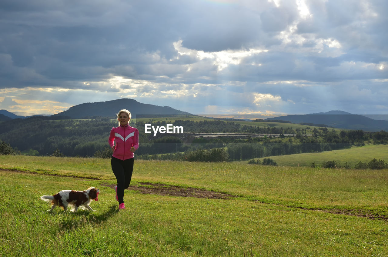 Lady running on a mountain meadow with her