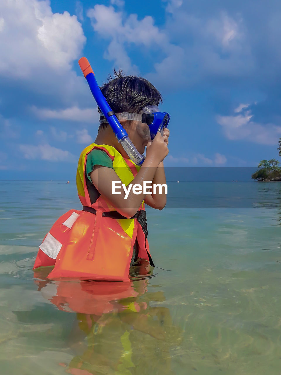 Boy in sea against sky