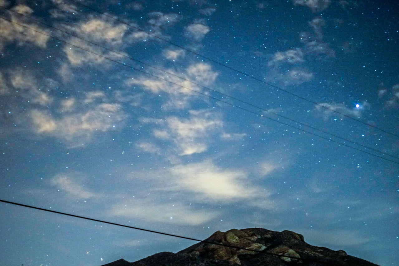 Low angle view of mountain against star field at dusk