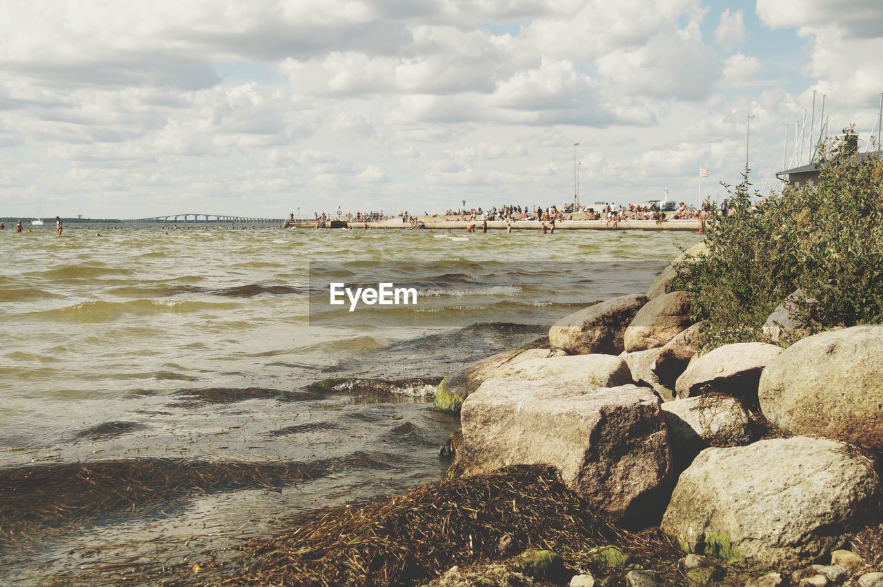 SCENIC VIEW OF ROCKS ON BEACH AGAINST SKY