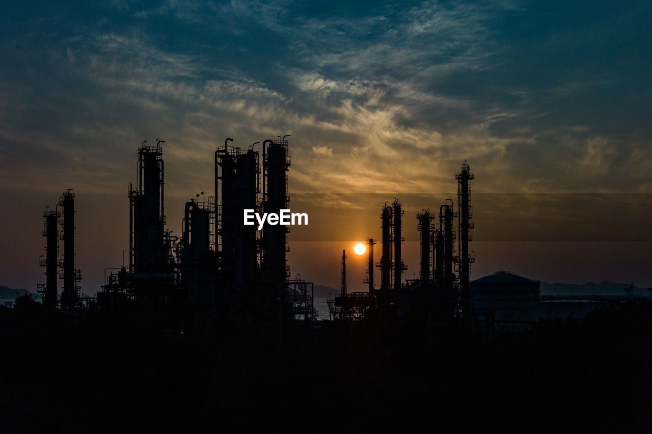 Silhouette of refinery building at sunset