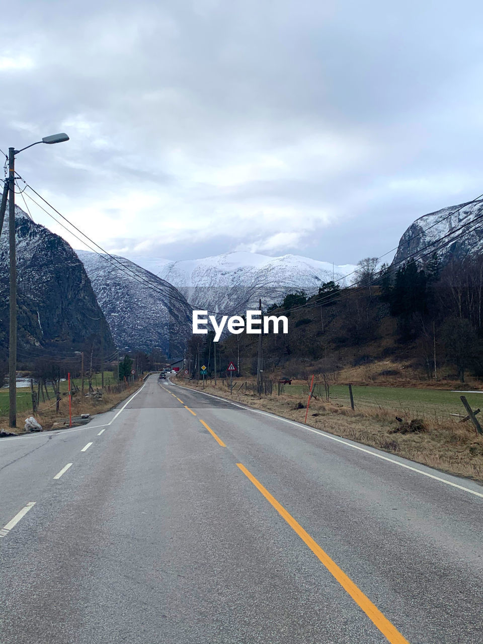 ROAD BY MOUNTAINS AGAINST SKY