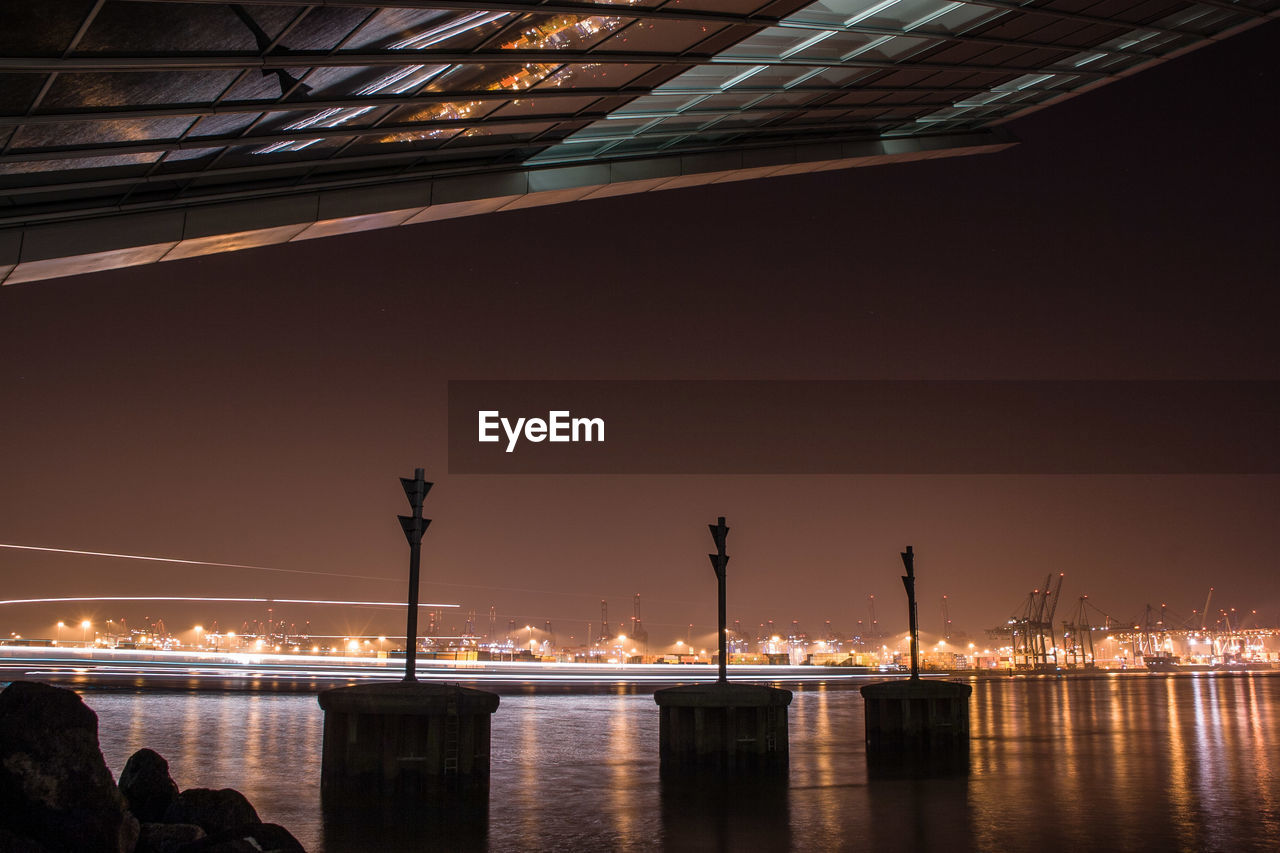 ILLUMINATED FACTORY BY RIVER AT NIGHT