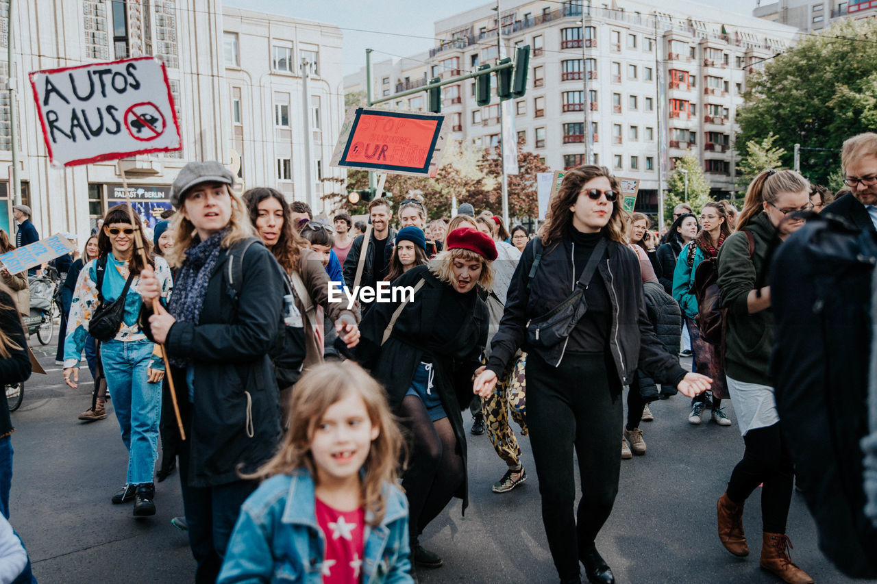 GROUP OF PEOPLE STANDING ON STREET IN CITY