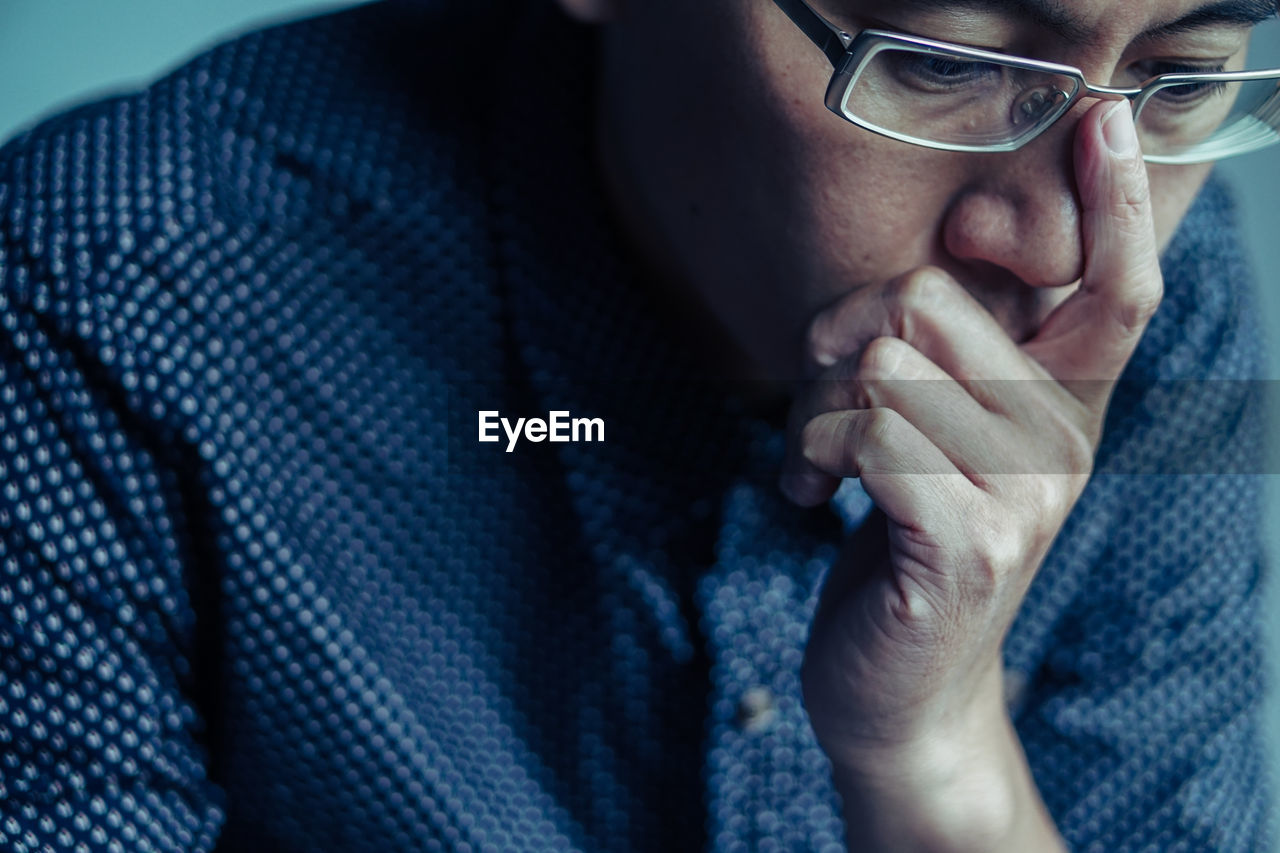 Close-up of worried mature man wearing eyeglasses