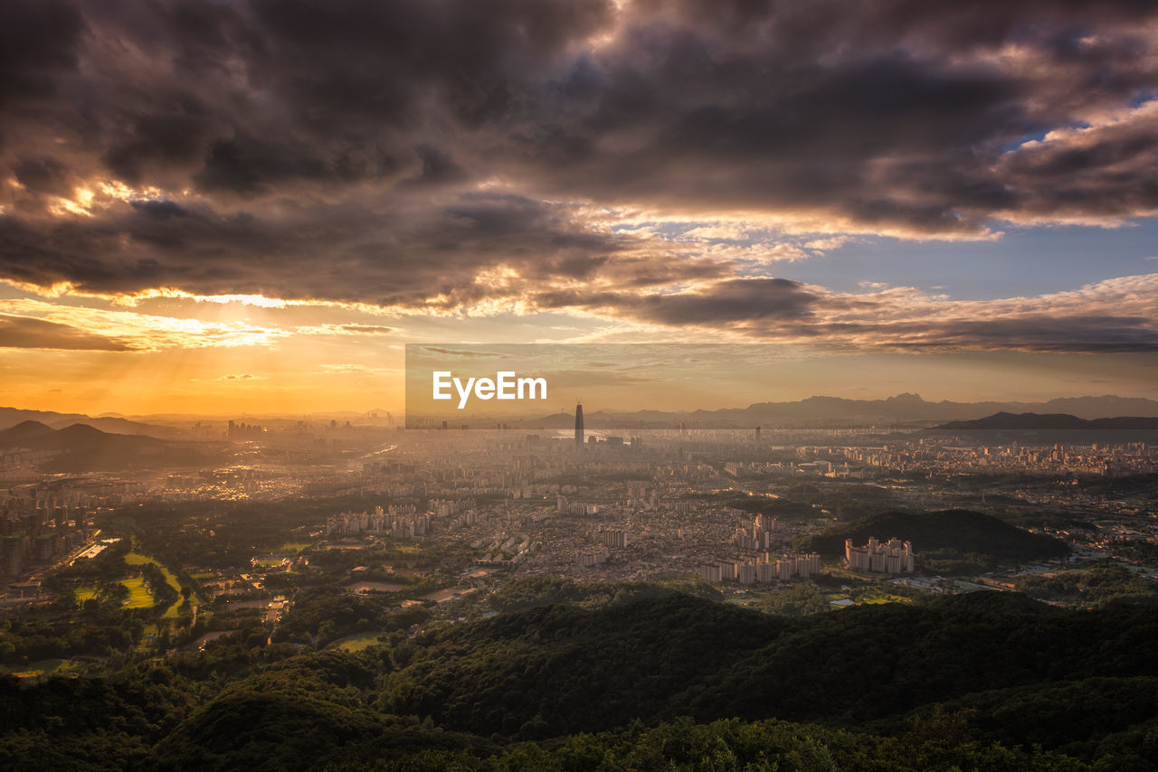 Aerial view of city against cloudy sky