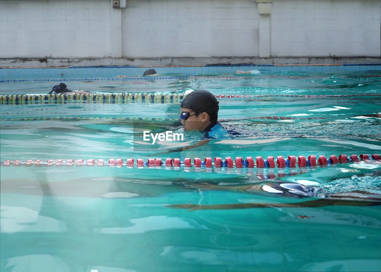 Side view of boy swimming in pool