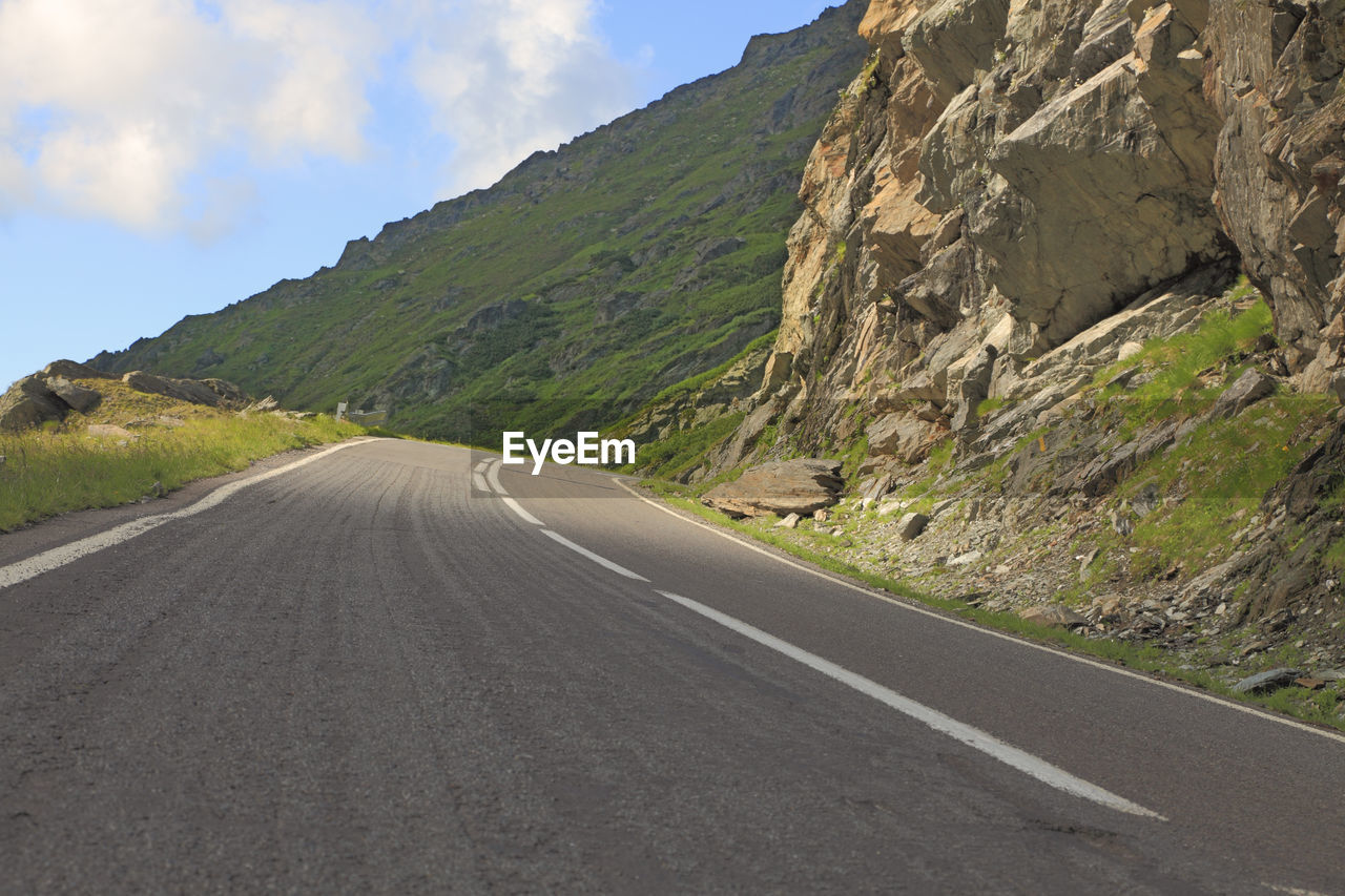 SURFACE LEVEL OF ROAD BY MOUNTAIN RANGE AGAINST SKY