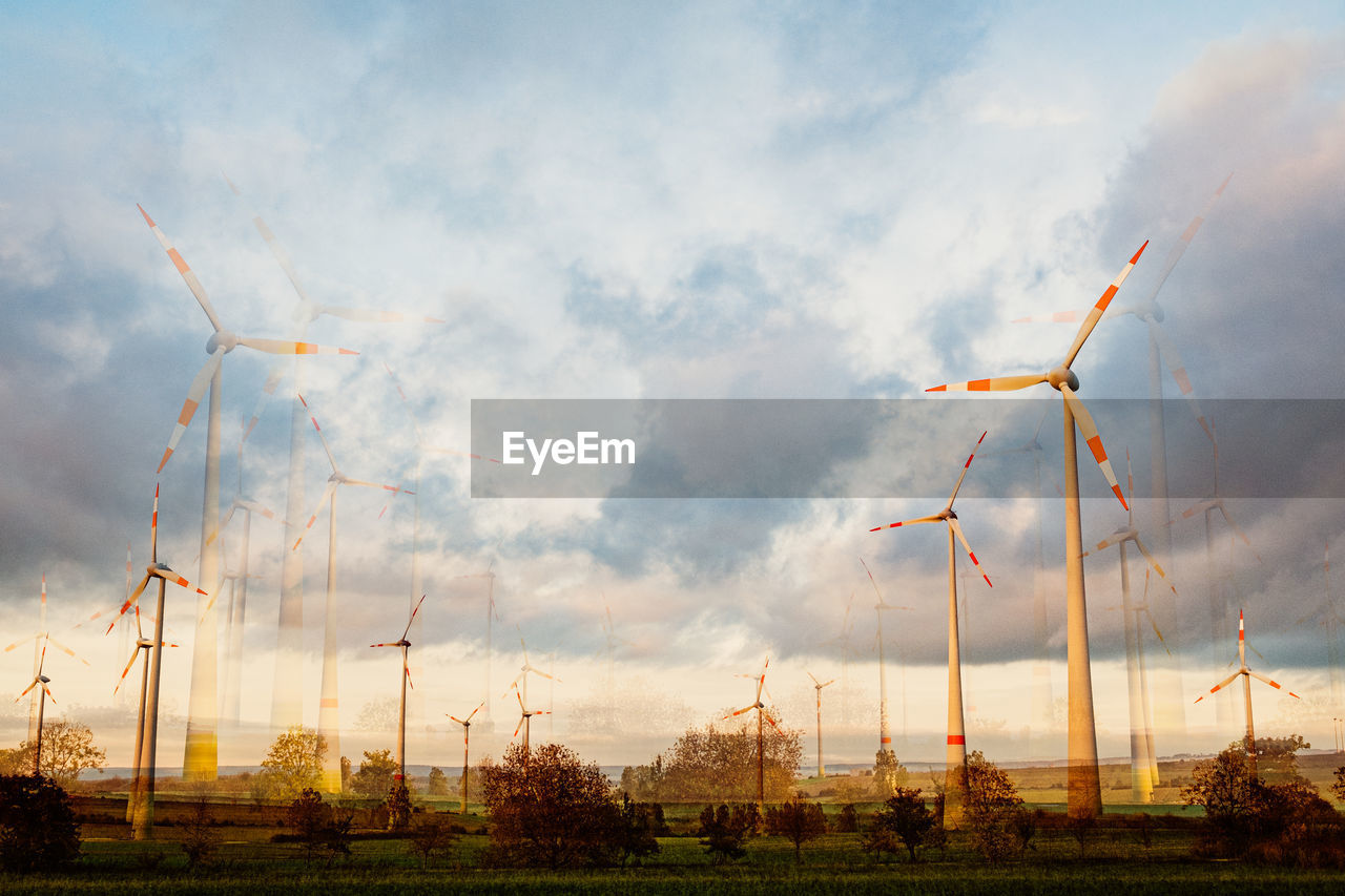 WIND TURBINES IN FIELD AGAINST SKY