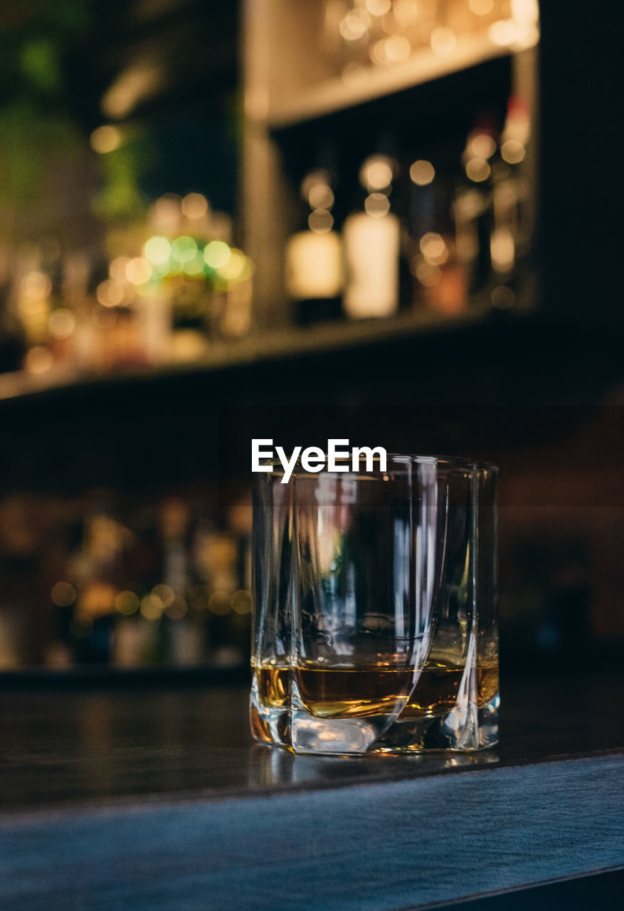 Close-up of whiskey glass on counter in bar