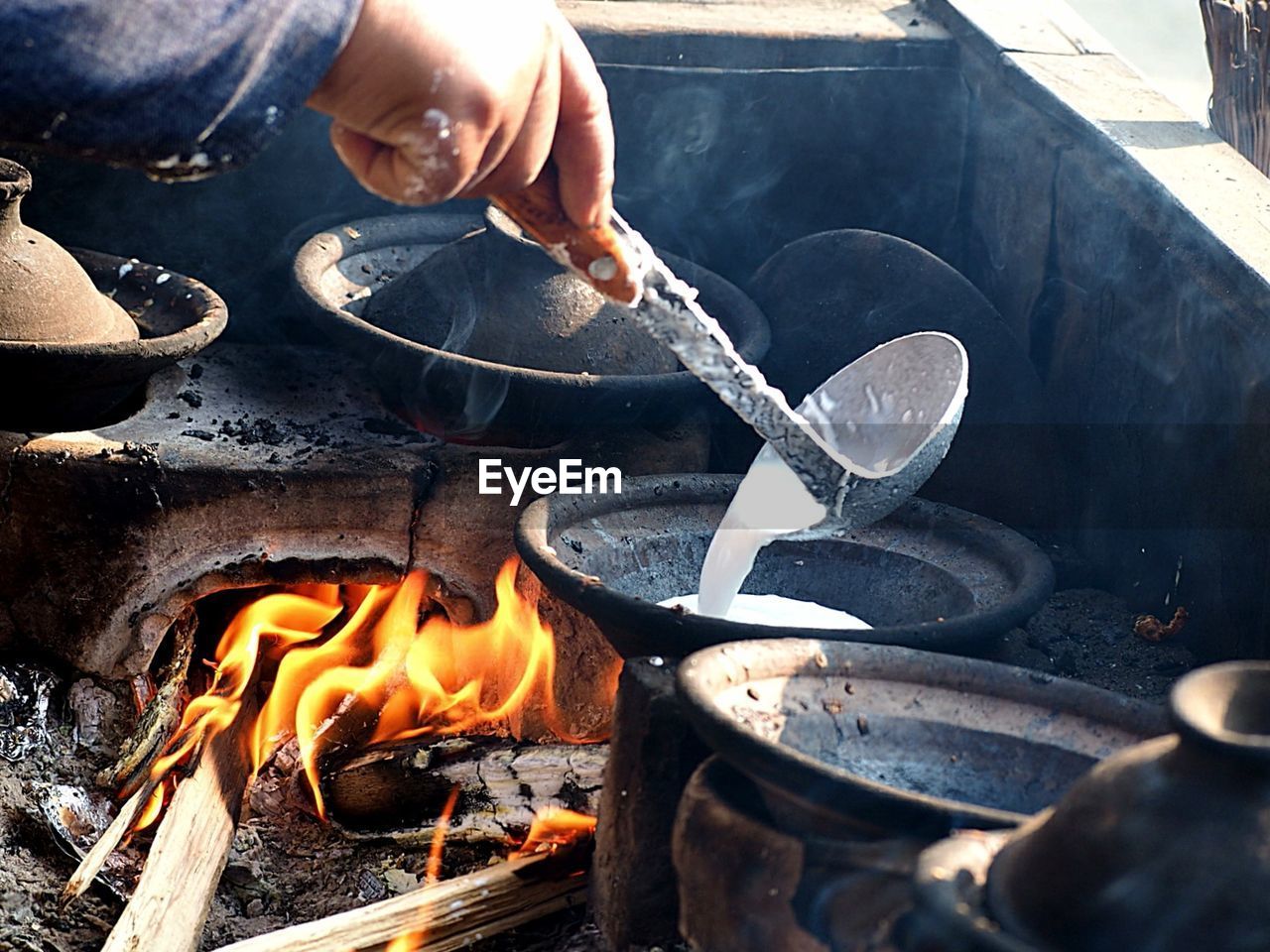 Cropped image of man preparing pancake in stove