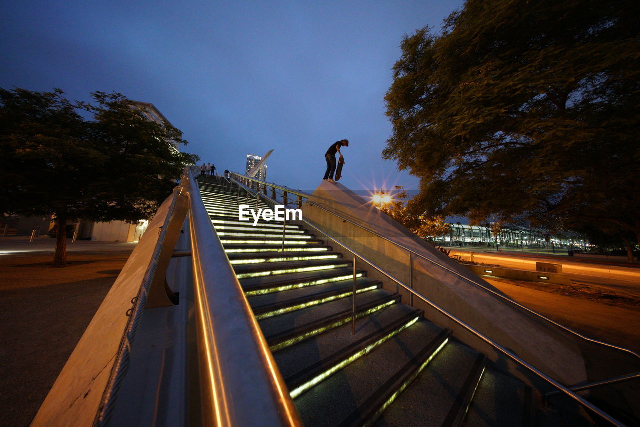 LOW ANGLE VIEW OF MAN JUMPING ON STEPS