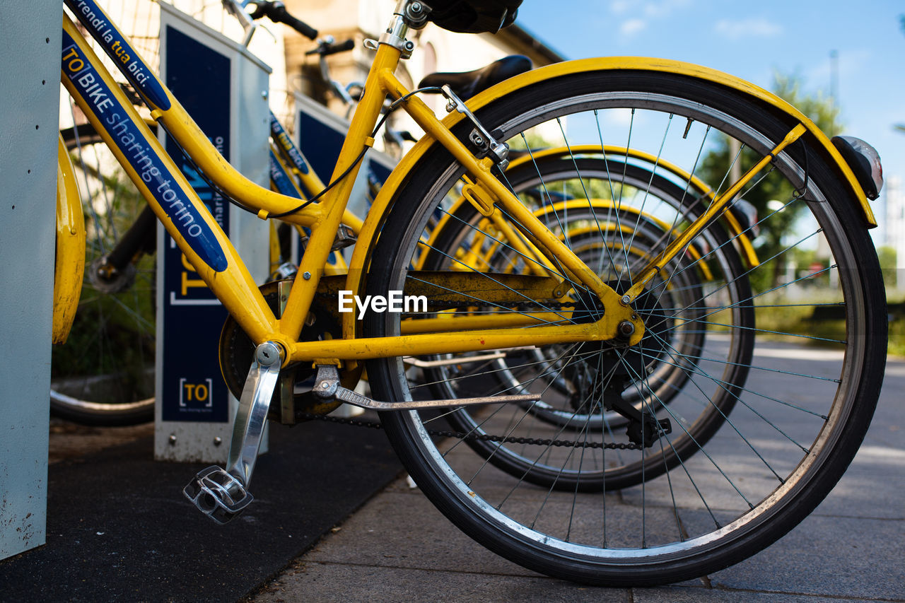 CLOSE-UP OF BICYCLE WHEEL AGAINST SKY