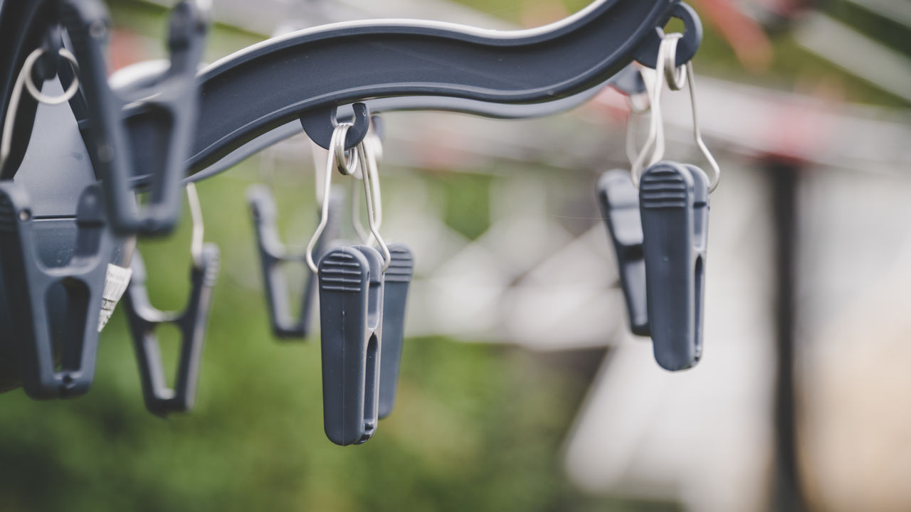 Close-up of plastic clothespins hanging on hook
