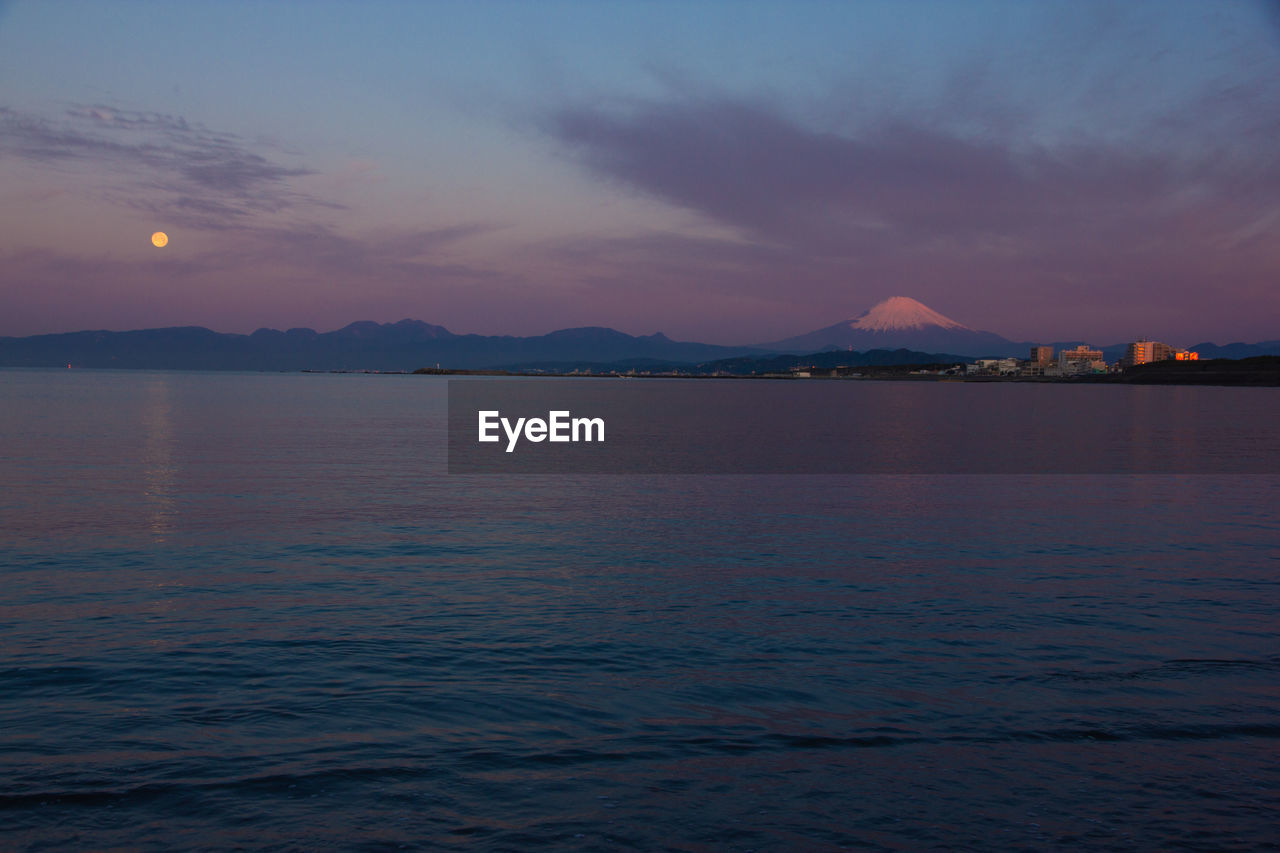 SCENIC VIEW OF SEA AND MOUNTAINS AGAINST SKY DURING SUNSET