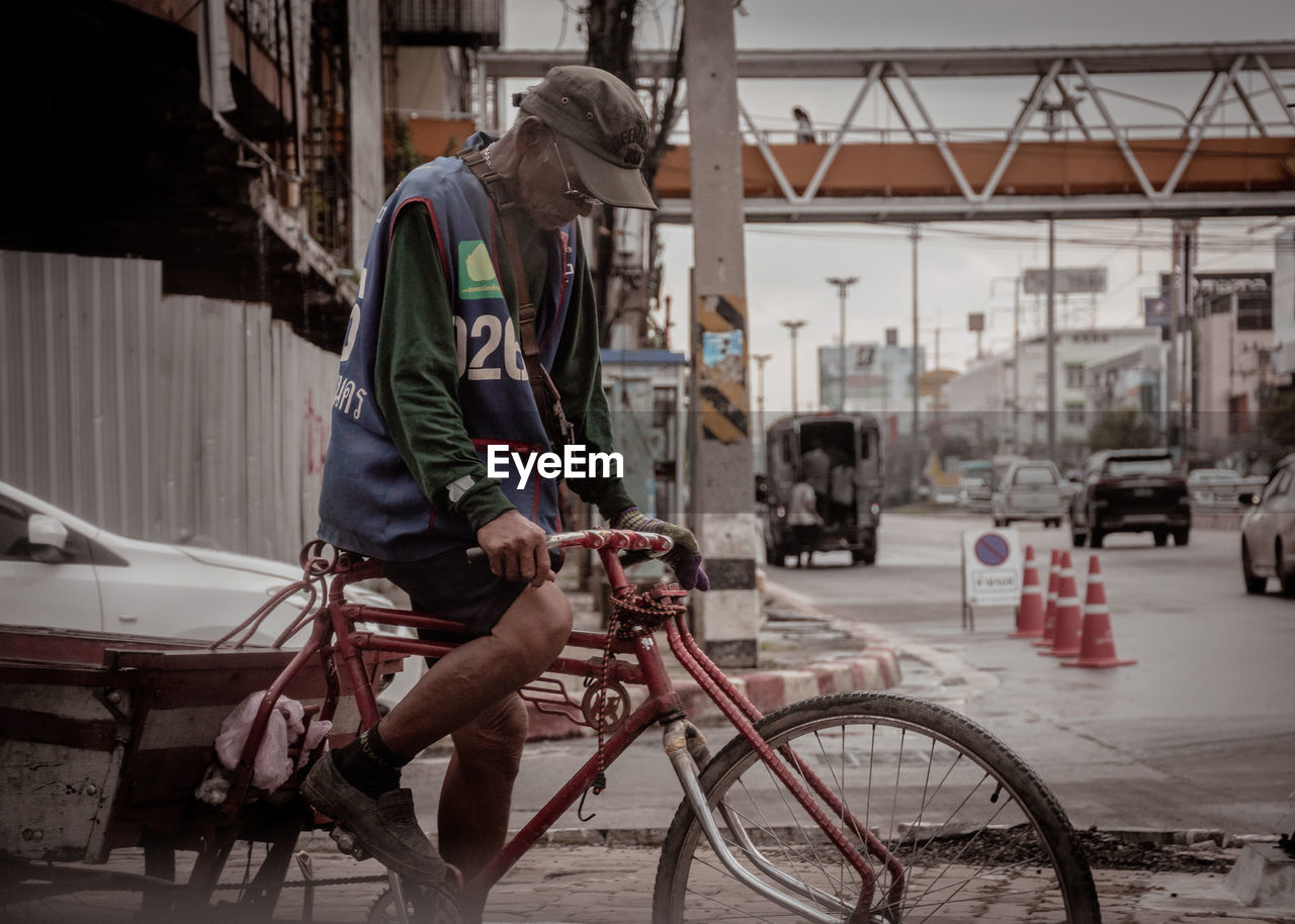 MAN WORKING WITH BICYCLE ON CITY