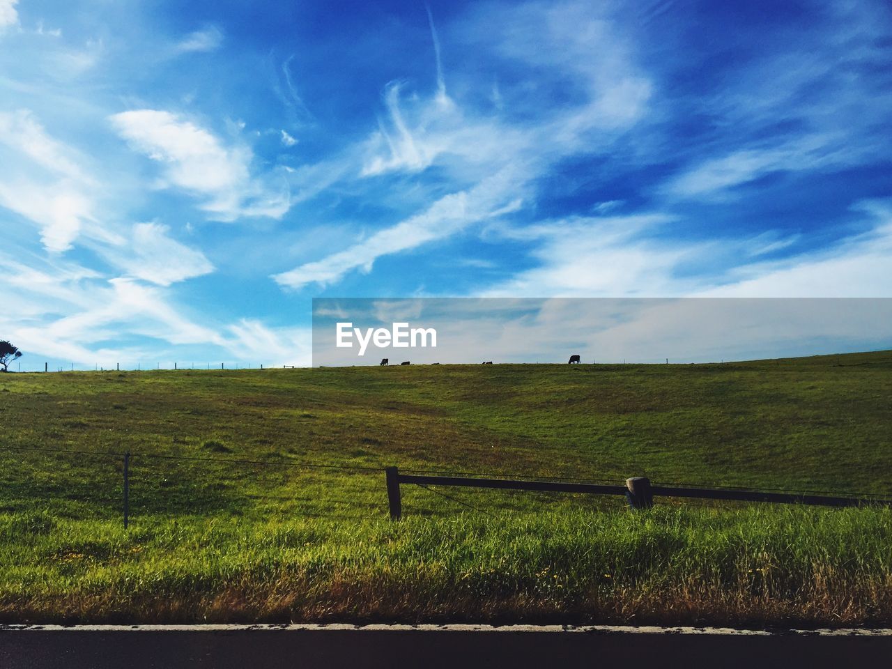 Road by landscape against cloudy sky