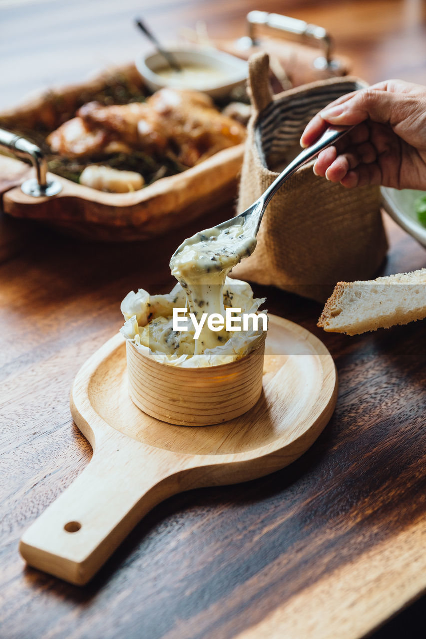 Cropped hand having food at table