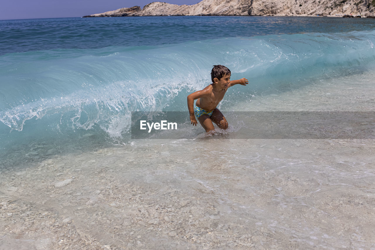 Little kid enjoying the waves on the beach