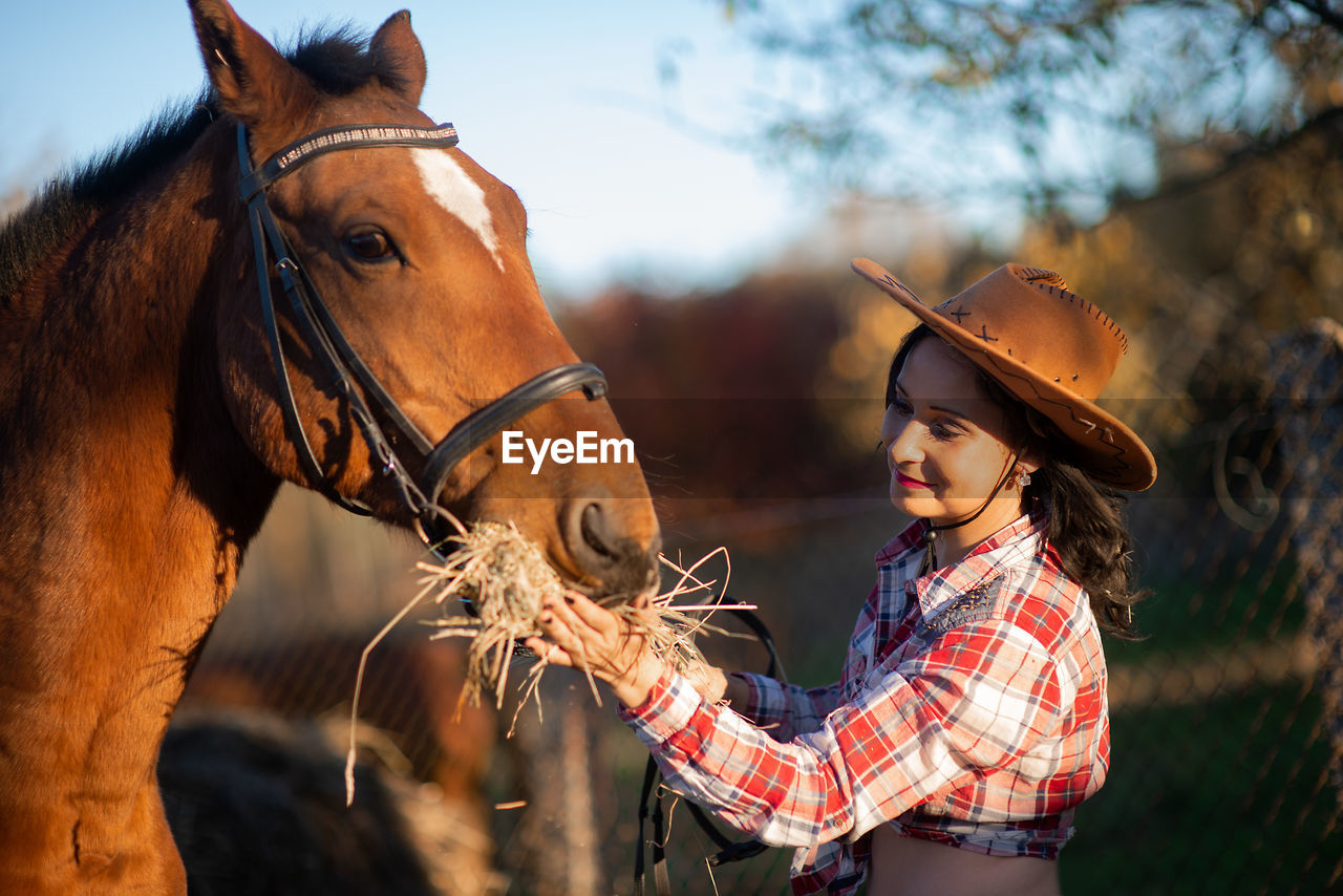 Woman feeding horse at ranch