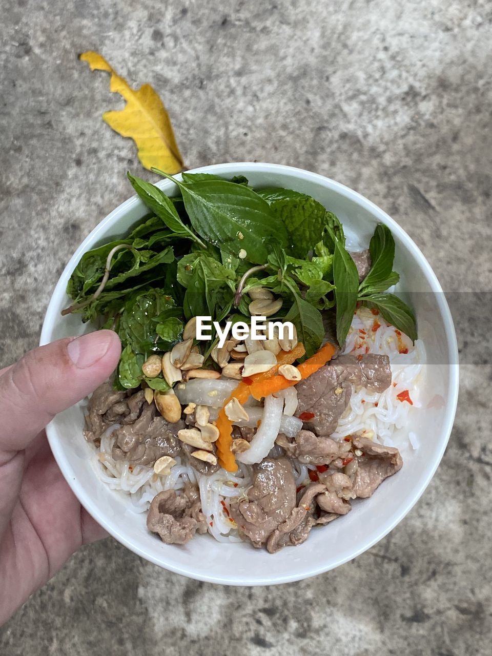 HIGH ANGLE VIEW OF HAND HOLDING BOWL OF FOOD