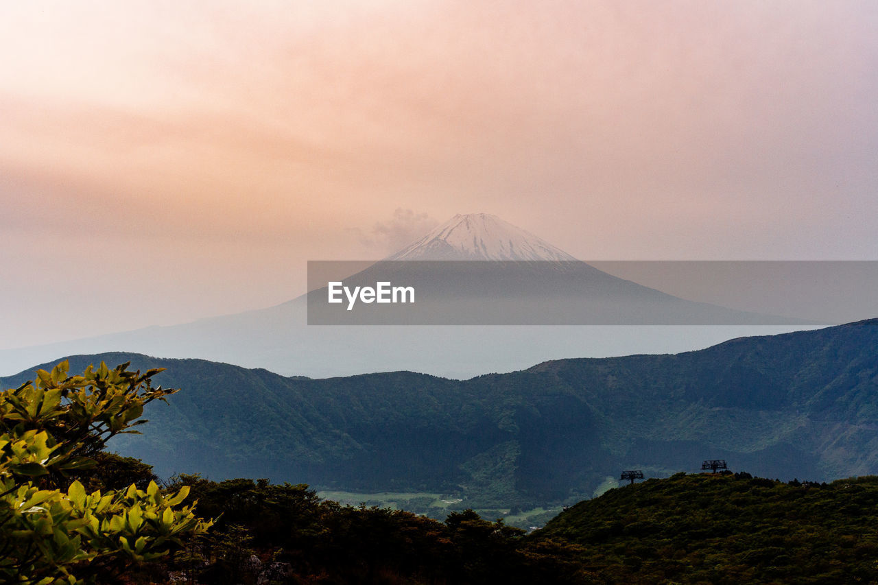 Scenic view of volcanic mountain against cloudy sky