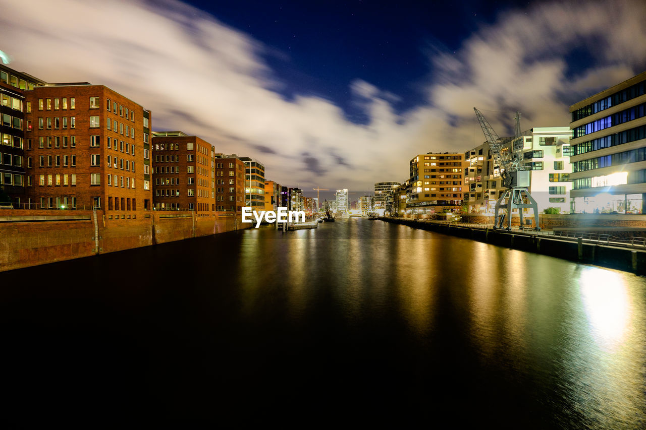 Buildings in city against cloudy sky