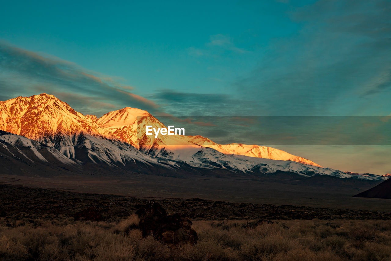 Scenic view of snowcapped mountains against sky during sunset