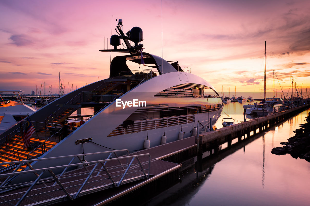 SHIP MOORED AT HARBOR DURING SUNSET