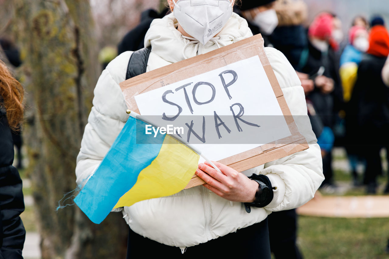 Stop war banner holding and ukraine flag at a demonstration in the city center in berlin