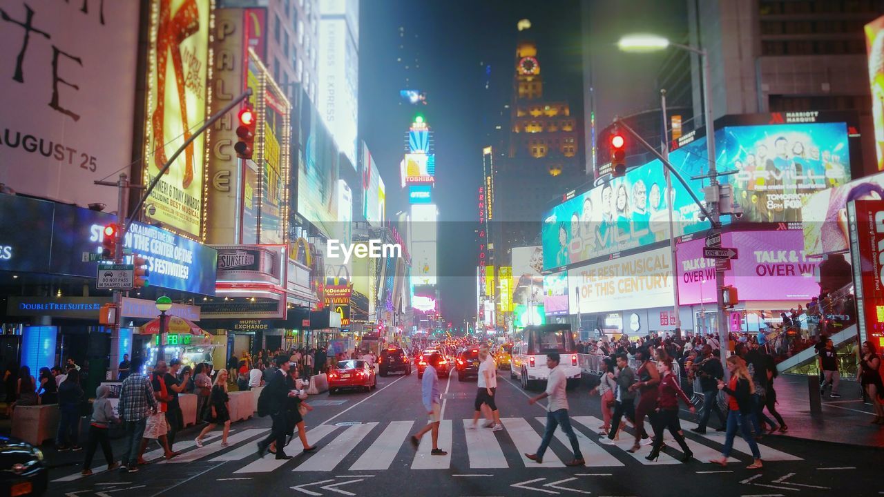 PEOPLE WALKING ON ROAD AT NIGHT