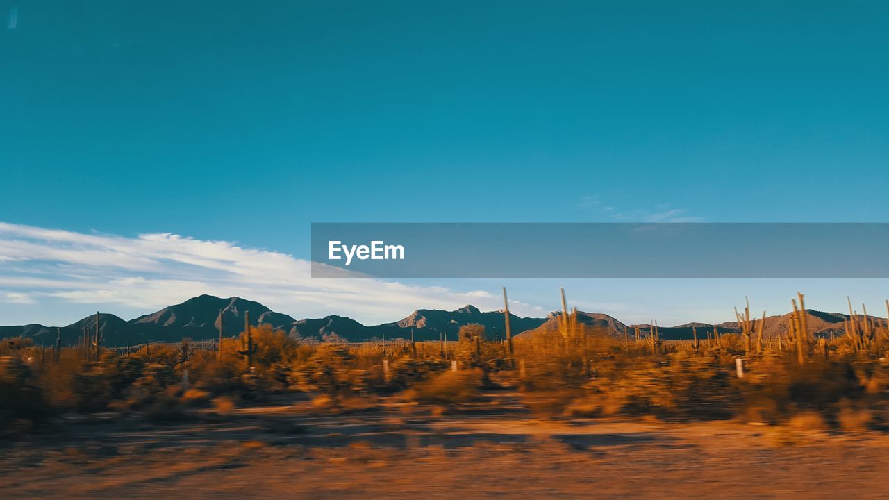 Scenic view of mountains against blue sky