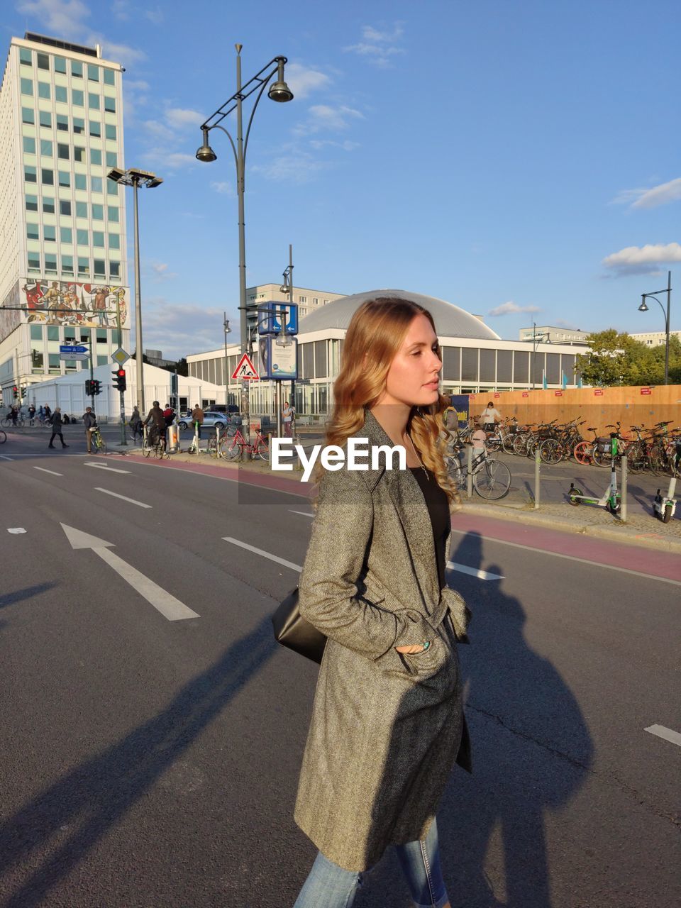 Young woman on road against sky in city