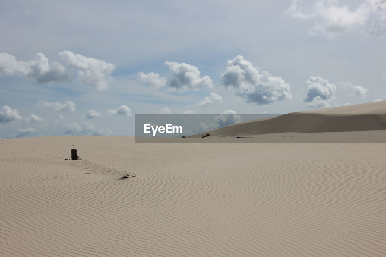 Scenic view of sand dunes against sky