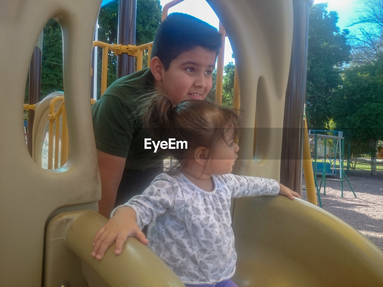 CUTE GIRL SITTING ON PLAYGROUND