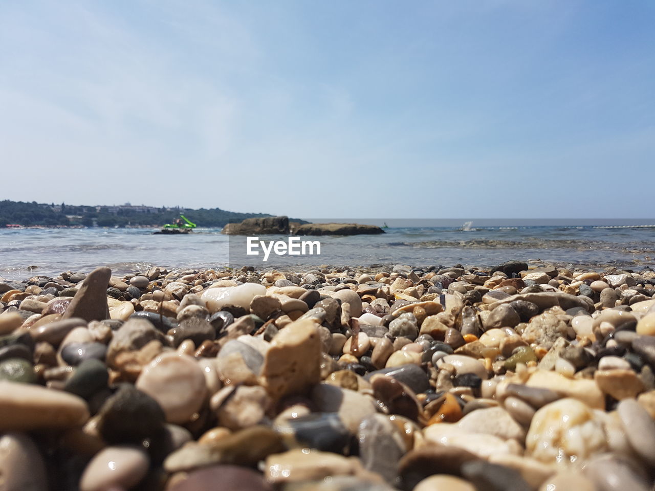 Pebble stones at beach against sky