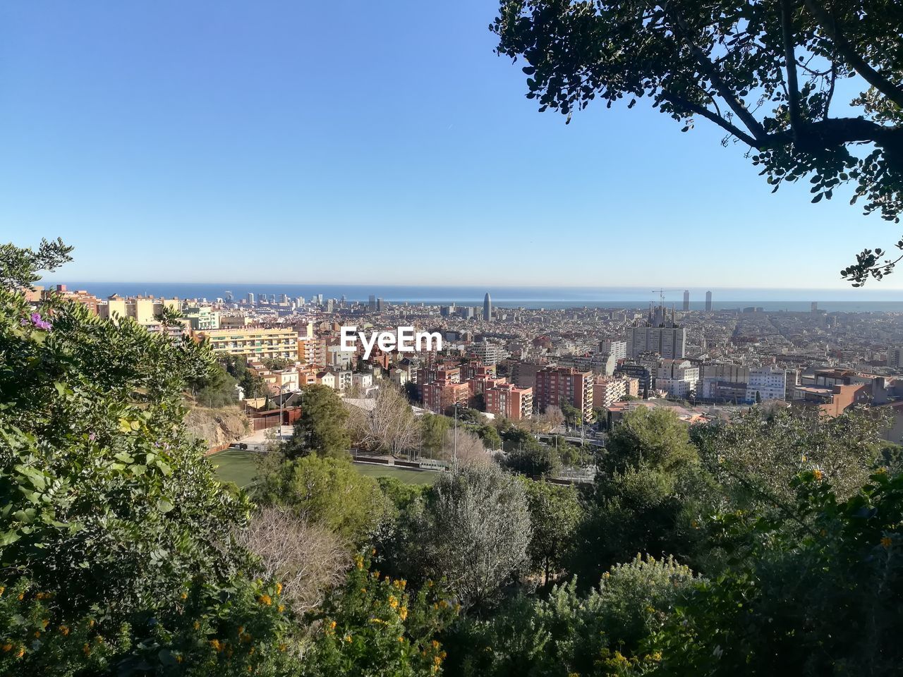 HIGH ANGLE VIEW OF TOWNSCAPE AND SEA AGAINST SKY