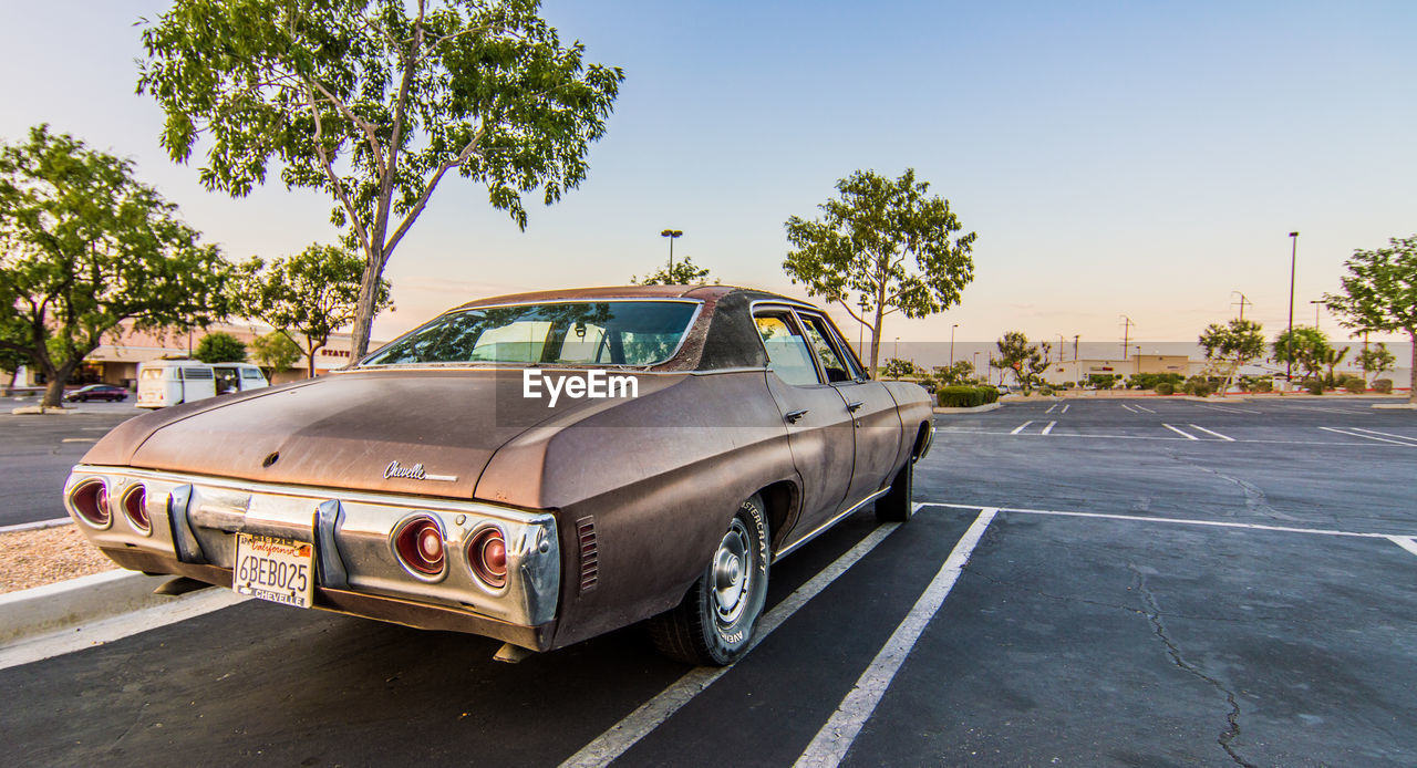 VINTAGE CAR ON ROAD AGAINST SKY