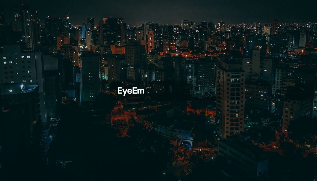 ILLUMINATED CITYSCAPE AGAINST SKY AT NIGHT