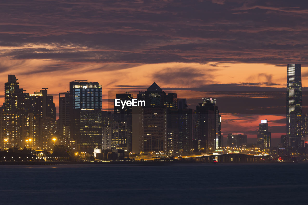 ILLUMINATED MODERN BUILDINGS AGAINST SKY DURING SUNSET