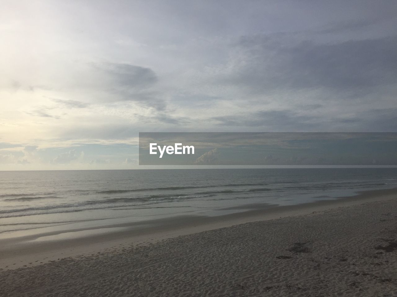 View of beach against cloudy sky