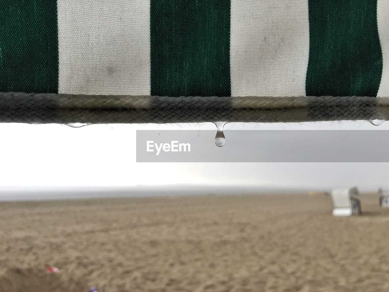 Close-up of water drop on hooded chair at beach