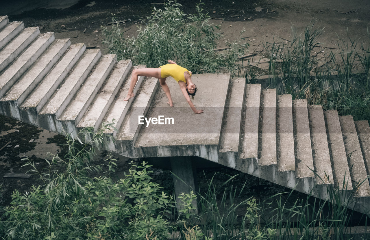 High angle view of young woman exercising on steps