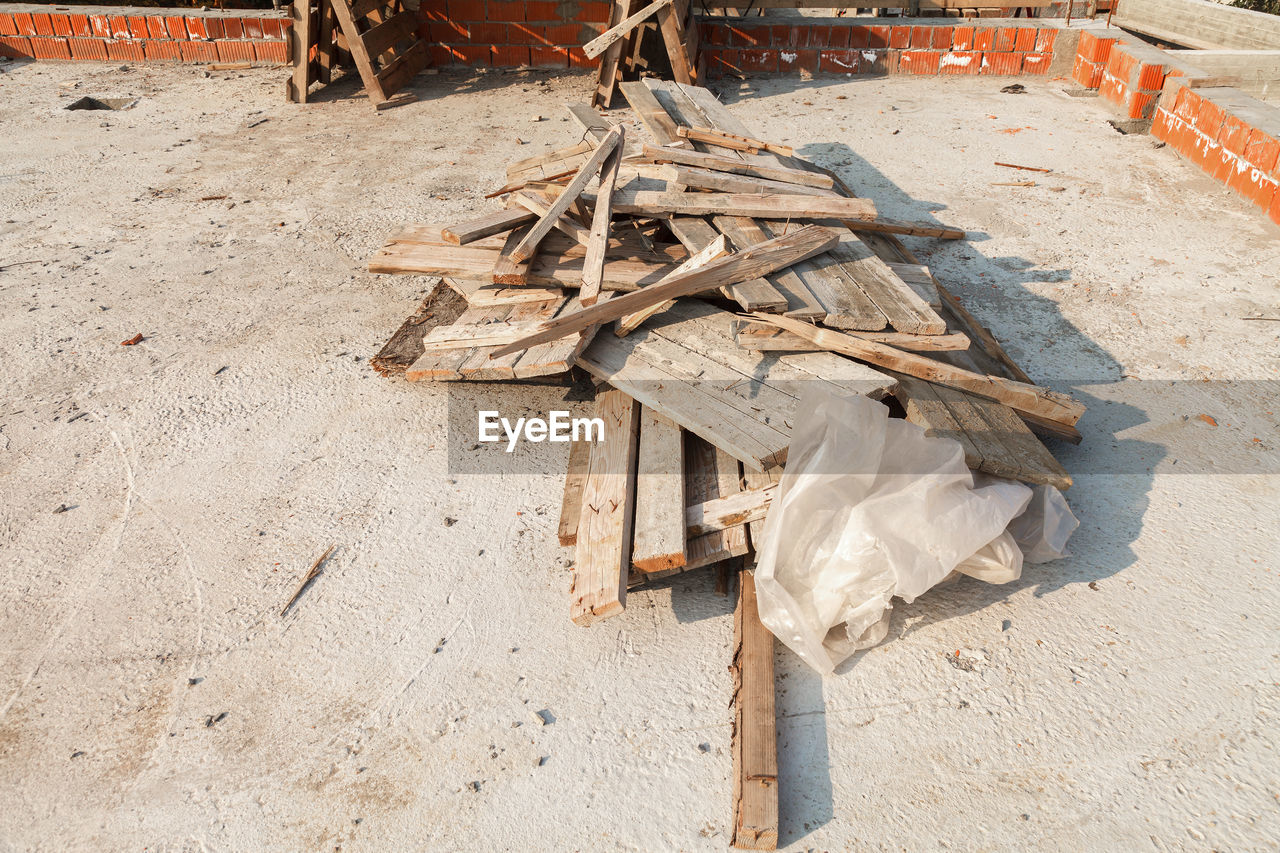 HIGH ANGLE VIEW OF GARBAGE CAN ON SAND