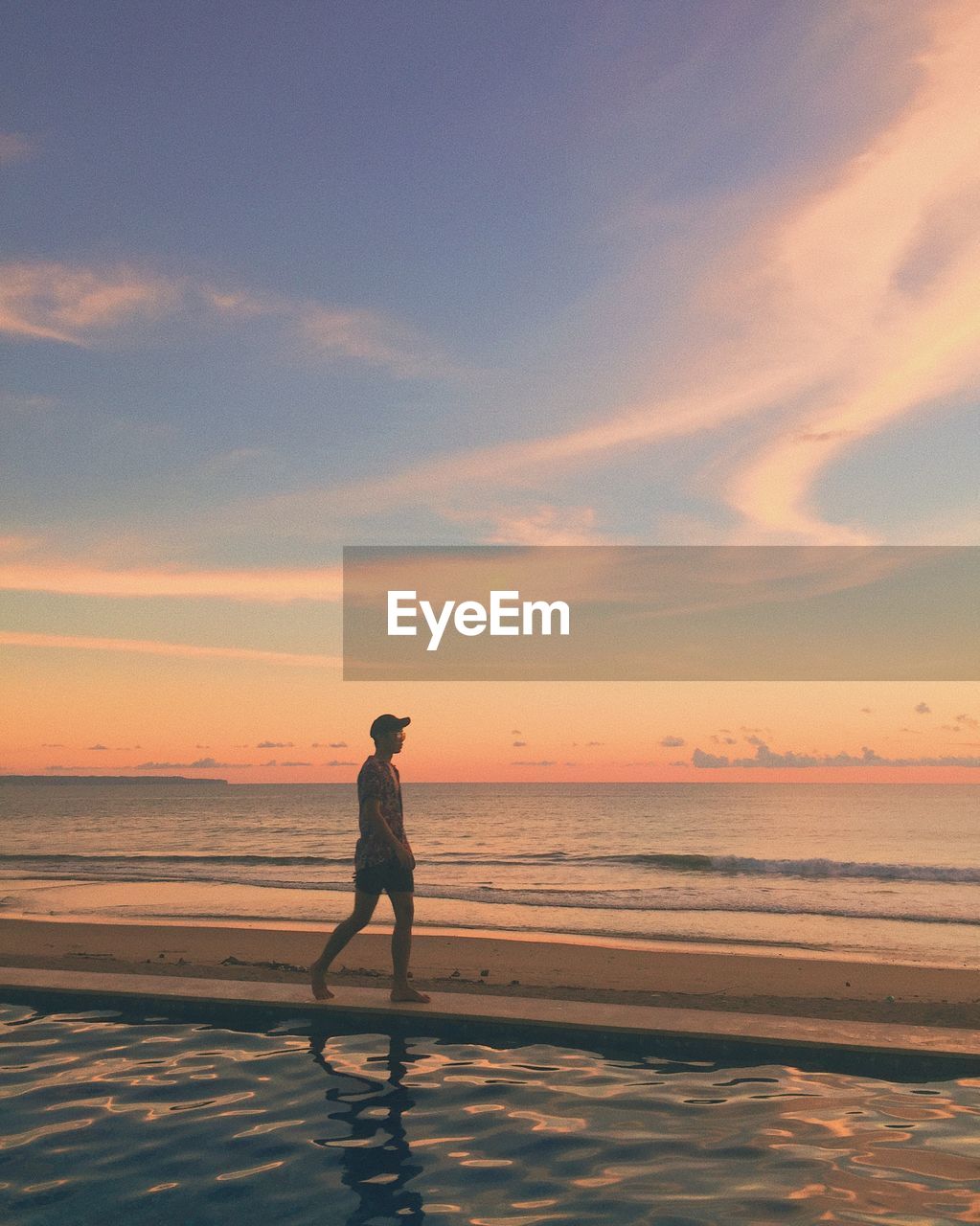 Full length of man standing on beach during sunset