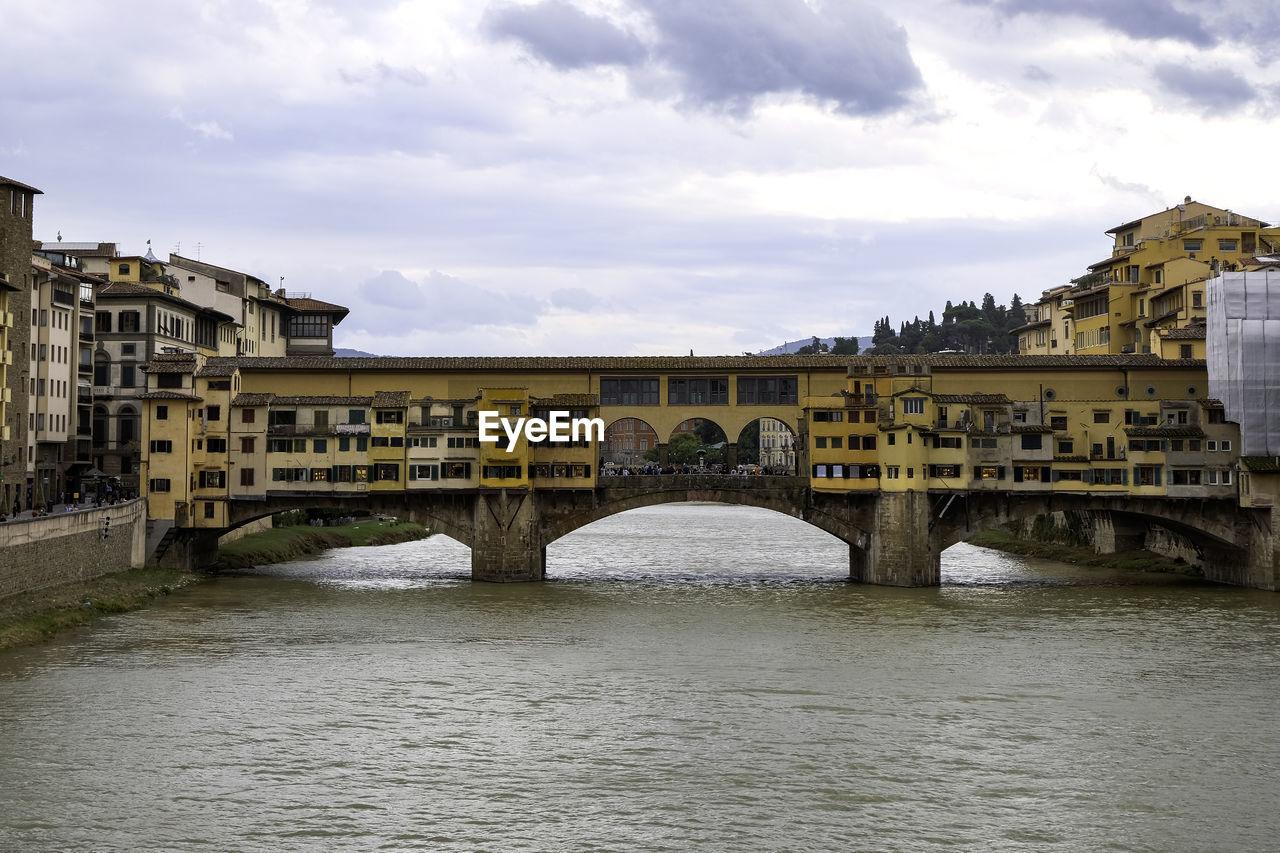 Ponte vecchio over arno river with its colorful little houses hanging - florence, tuscany, italy
