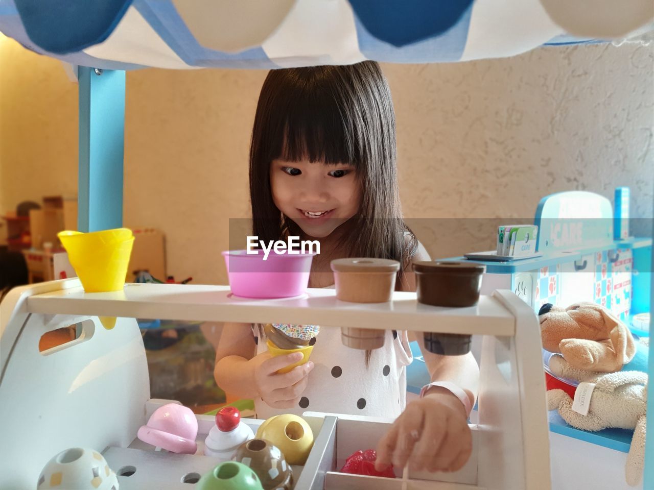 Happy girl playing with toys at home