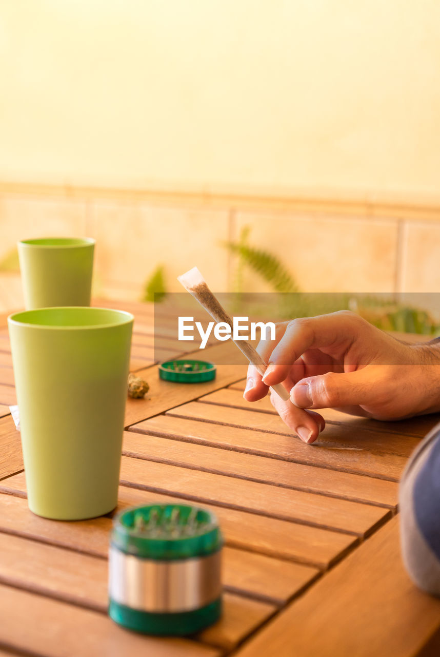 Cropped hand of person using mobile phone on table