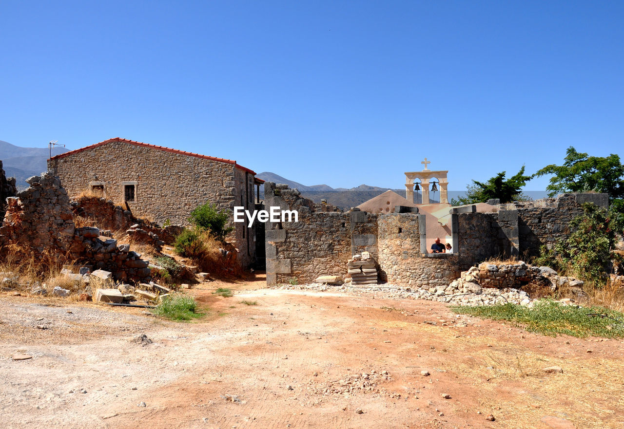 architecture, built structure, building exterior, building, ruins, history, village, sky, the past, clear sky, nature, blue, house, ancient history, no people, landscape, fortification, travel destinations, sunny, desert, land, old, travel, plant, copy space, ancient, tree, wall, outdoors, rural area, old ruin, day, scenics - nature, residential district, abandoned, rural scene, brick, environment