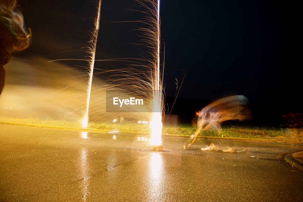 LIGHT TRAILS ON ROAD AGAINST SKY